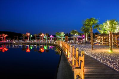 Holzsteg am Thermenstrand bei Nacht mit Lichtern