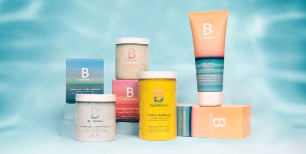 Vier bunte Produktverpackungen stehen nebeneinander vor einem blauen Hintergrund