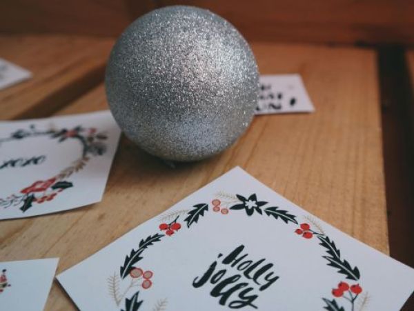 Weihnachtskarte gestalten Weihnachtskarte und Weihnachtskugel auf einem Holztisch