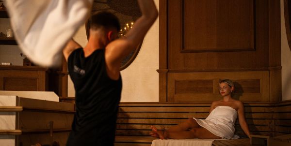 Kaffehaus-Sauna mit Aufgießer und Saunagästen