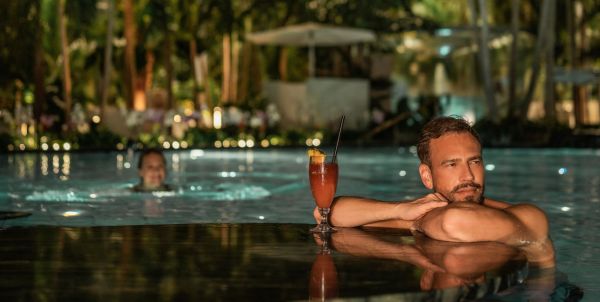 Poolbar im Wasser umgeben von Palmen
