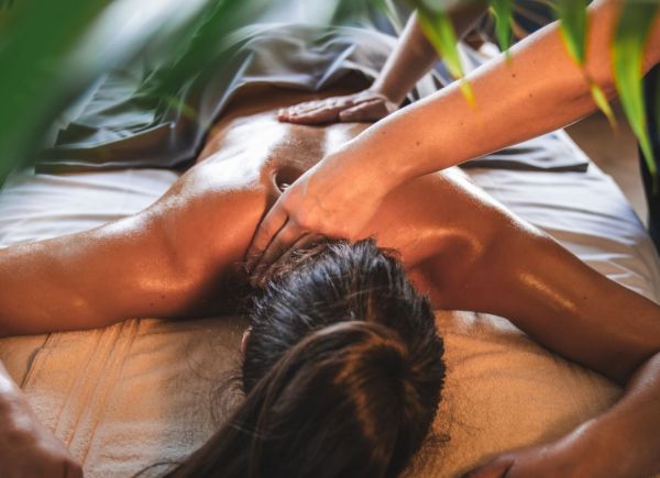 Frau auf Massageliege und wird massiert