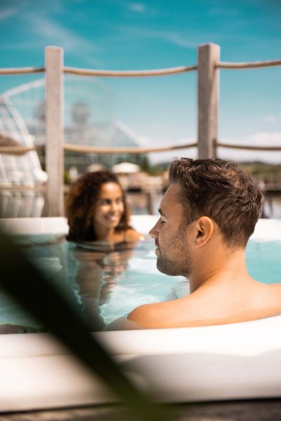 Zwei Personen entspannen in einem Pool mit türkisenem Wasser