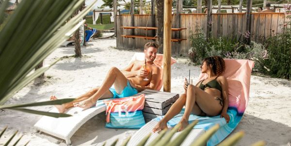Pärchen liegt auf Strandliegen am Strand