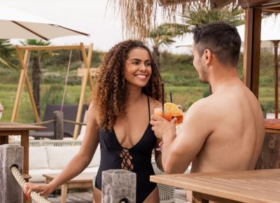 Drei Personen sitzen an einer Strand Bar