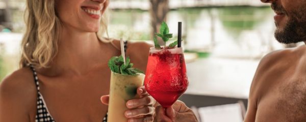Zwei Personen stoßen mit Cocktails an