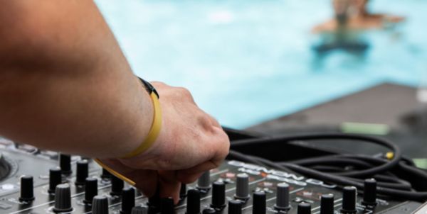 Hand auf DJ-Pult vor einer Lagune