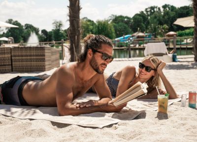 zwei Personen liegen am Strand