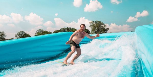 Mann surft auf einer Surfwelle