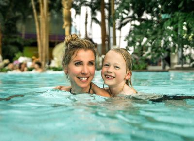 Mutter schwimmt mit Kind im Wasser