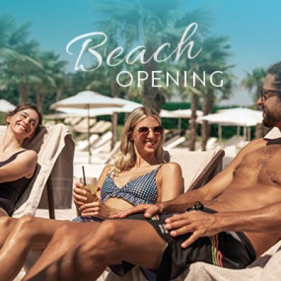 Drei Menschen liegen auf einer Sonnenliege am Strand