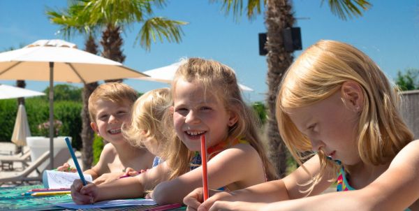 Kinder malen mit Buntstiften am Strand