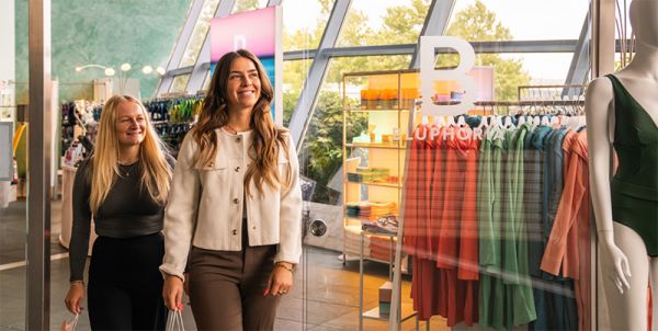 Two women in front of a modern shop