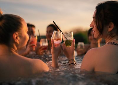 drei Personen lachen und sitzen am Poolrand