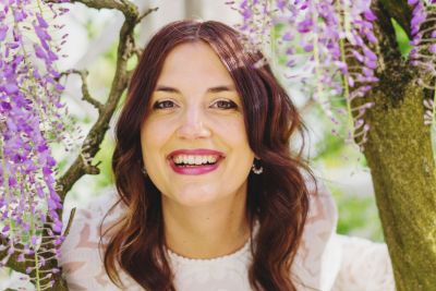 A woman stands amongst purple flowers