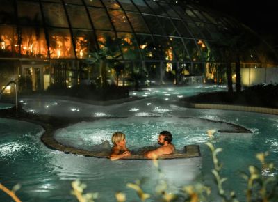 Zwei Personen schwimmen bei Nacht im Wasser