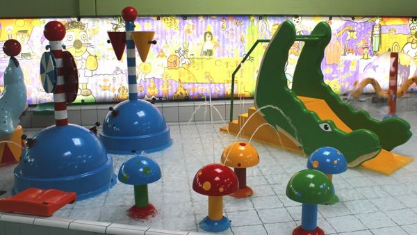 Kinderbecken mit Wasserspielzeug und Rutsche